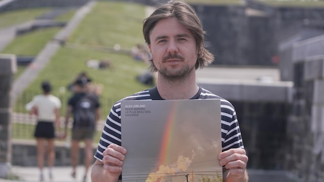 Alex Leblanc tient son album dans les mains.