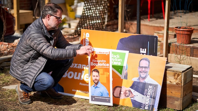 Alexandre Boulerice regarde sa collection de pancartes électorales.