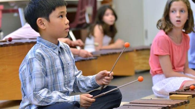 Photo d'un garçon qui joue du xylophone.