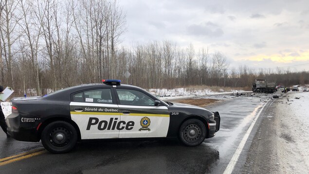 Une voiture de la Sûreté du Québec bloque l'accès à une route. 