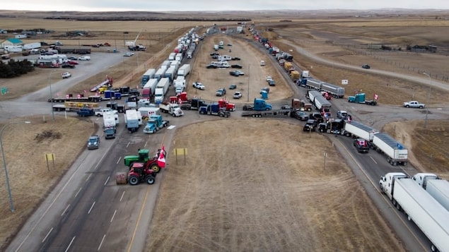 A truck convoy of anti-COVID-19 vaccine mandate demonstrators block a highway at the busy border crossing in Coutts, Alta., in a file photo from Feb. 2, 2022.