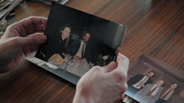A person holding family photos in their hands.
