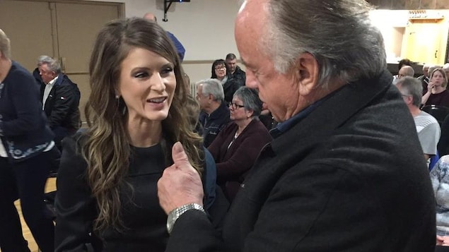 Amanda Simard serre la main d'un homme dans une salle comble