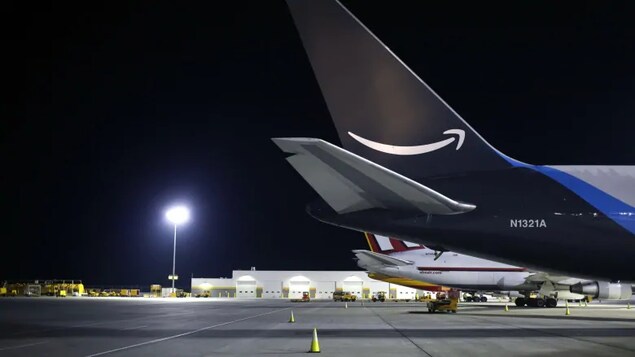 L'arrière d'un avion posé sur une piste d'atterrissage, aborrant le logo d'Amazon.