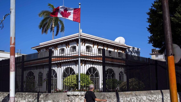 Un drapeau canadien flotte devant l'édifice clôturé de l'ambassade canadienne à Cuba.