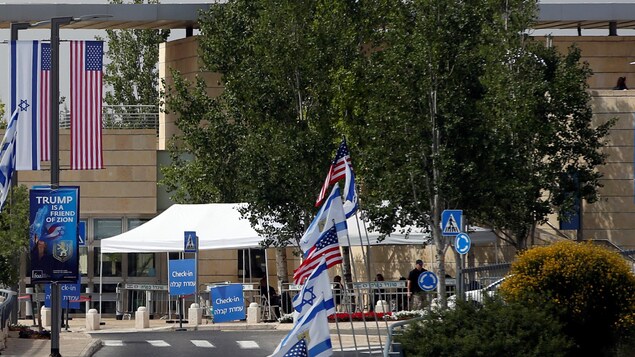 Des drapeaux américains et israéliens sont visibles le long de la route menant à l'immeuble qui abrite désormais l'ambassade américaine à Jérusalem. « Trump est un ami de Sion », peut-on lire sur une affiche officielle. Des drapeaux américains et israéliens sont visibles le long de la route menant à l'immeuble qui abrite désormais l'ambassade américaine à Jérusalem. « Trump est un ami de Sion », peut-on lire sur une affiche officielle.