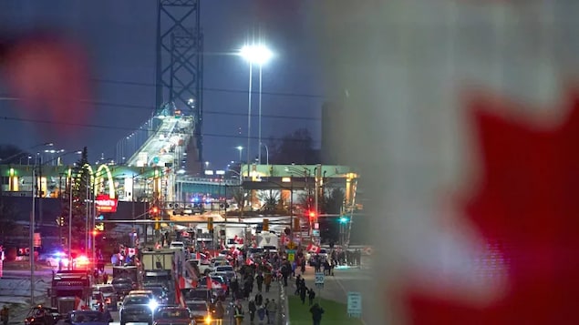 Demonstrators in Windsor, Ont., block the roadway Wednesday at the Ambassador Bridge, the busiest border crossing between Canada and the U.S. and a vital link for commercial cargo.