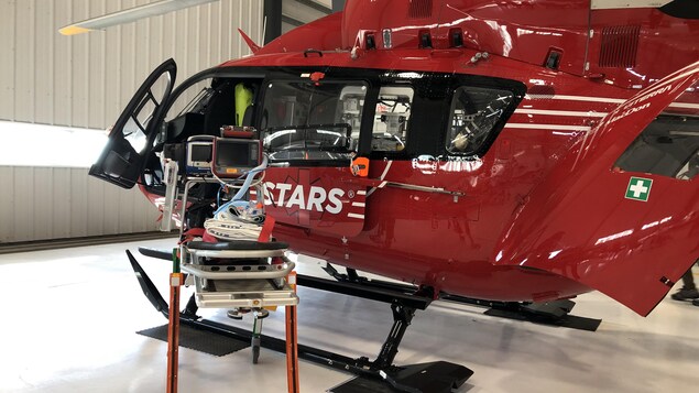 Un hélicoptère rouge qui sert à transporter des patients par voie aérienne.