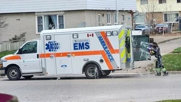 Un travailleur des services médicaux d'urgence de Chatham-Kent est en train de déposer une table de billard à l'arrière d'une ambulance.