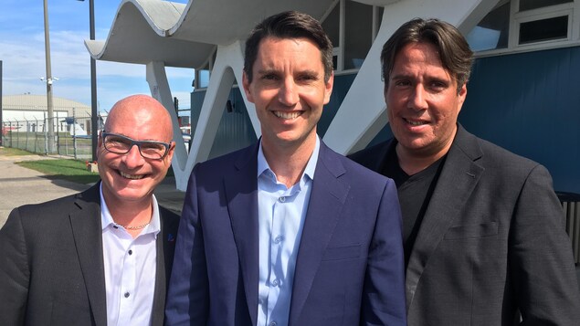Les trois hommes sur le terrain de l'aéroport de Trois-Rivières