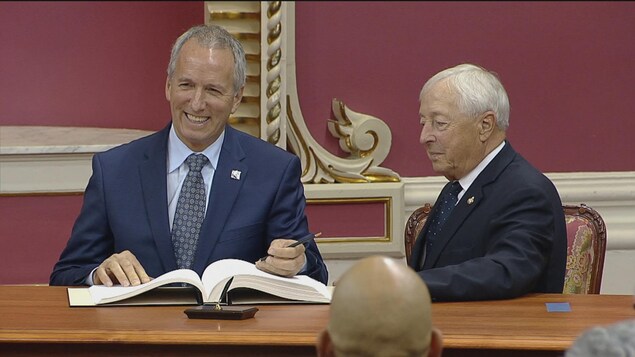 André Lamontagne qui signe aux côtés du lieutenant-gouverneur, à Québec André Lamontagne qui signe aux côtés du lieutenant-gouverneur, à Québec