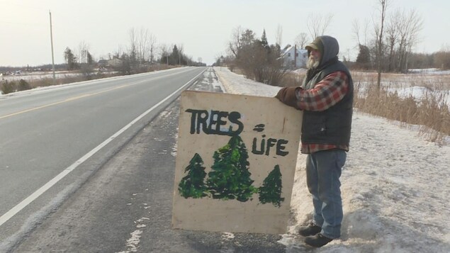 Un manifestant, sur le bord de la route 34 à Vankleek Hill, manifeste avec une une pancarte où on peut lire « Tree = Life ». Un manifestant, sur le bord de la route 34 à Vankleek Hill, manifeste avec une une pancarte où on peut lire « Tree = Life ».