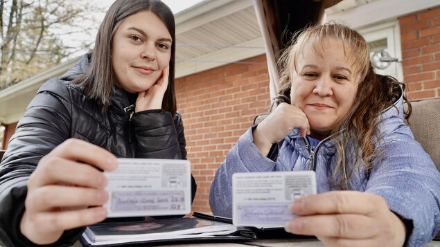 Deux femmes tenant leur carte d'assurance-maladie signée pour le don d'organe.