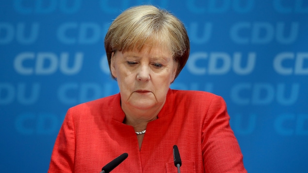 Angela Merkel, les yeux baissés, en conférence de presse.