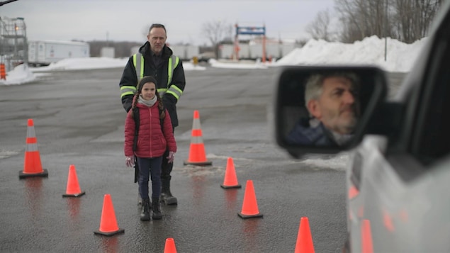 Une enfant et un adulte entre une série de cônes au sol