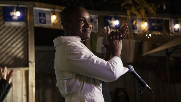 Annamie Paul, souriante, devant un micro.