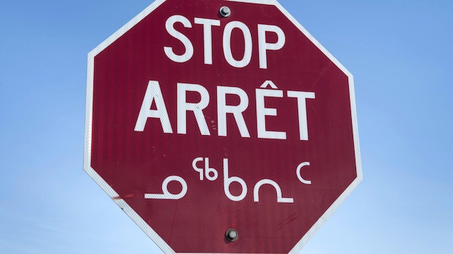 Un panneau de signalisation en anglais, français et inuit situé à Iqaluit, au Nunavut.
