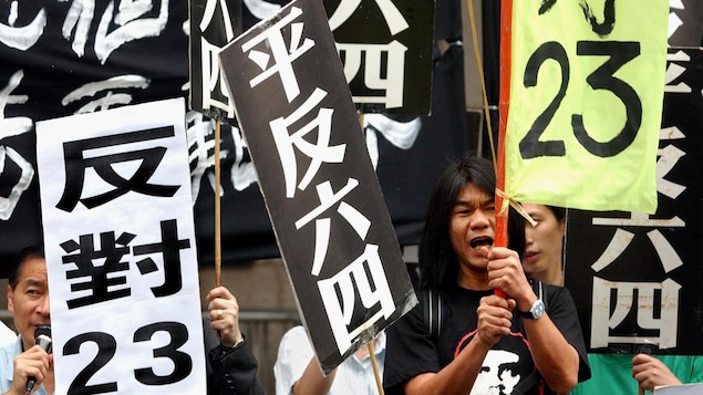 Pro-democracy activists demonstrate outside Hong Kong legislative chambers Wednesday, May 28, 2003, chanting slogans and demanding an accounting for Beijing's bloody crackdown against pro-democracy forces Tiananmen Square 14 years ago. Veteran pro-democracy campaigner "Longhair" Leung Kwok-hung, seen at right foreground, acknowledged the motion would fail. The banners read "Avenge June 4th" and "Objection to article 23" referring to a proposed anti-subversion law which critics fear will crush d