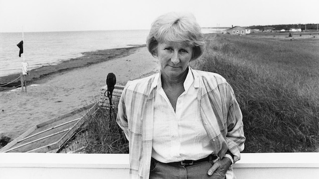 Antonine Maillet posant devant une plage en Acadie.