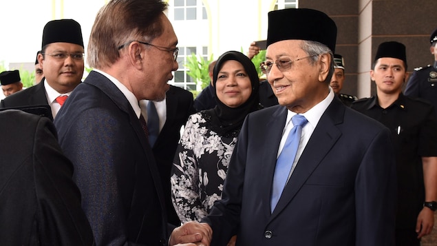 Anwar Ibrahim serre la main du premier ministre Mahathir Mohamad. Anwar Ibrahim serre la main du premier ministre Mahathir Mohamad.