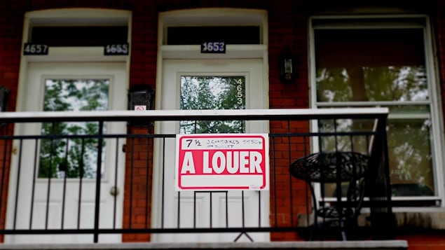 Un immeuble à appartements à Montréal avec une pancarte À louer devant l'une des portes.