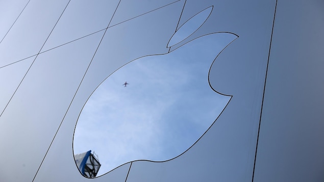Le logo d'Apple en forme de pomme croquée sur un bâtiment vitré.