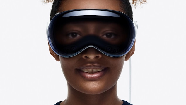 Une jeune femme porte un casque de réalité virtuelle qui ressemble à des lunettes de ski.