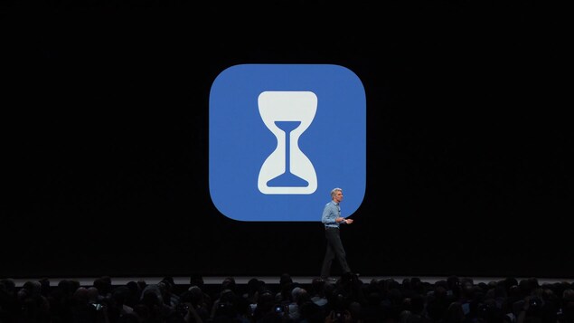 Une capture d'écran de la présentation montrant le logo de l'application Screen Time (un sablier dans un carré bleu aux coins arrondis) derrière un présentateur sur la scène. Une capture d'écran de la présentation montrant le logo de l'application Screen Time (un sablier dans un carré bleu aux coins arrondis) derrière un présentateur sur la scène.