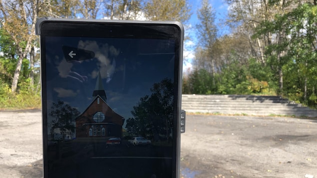 Une église apparaît dans l'écran d'un appareil mobile pointé sur le site de Saint-Jean-Vianney.