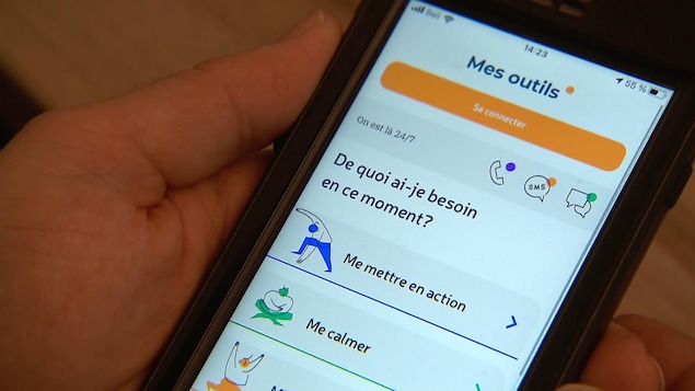 Un téléphone intelligent dans une main. On voit une application sur le bien-être ouvert, avec des thèmes comme Me mettre en action et me calmer.