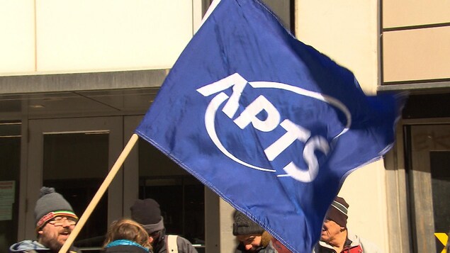 Un manifestant avec un drapeau de l'APTS.