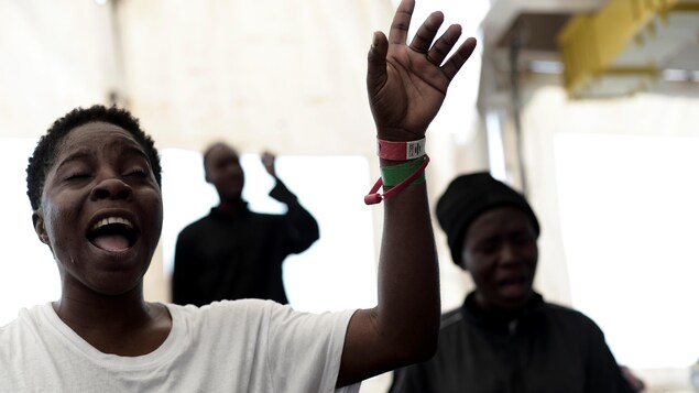 Des migrants chantent. Des migrants chantent.