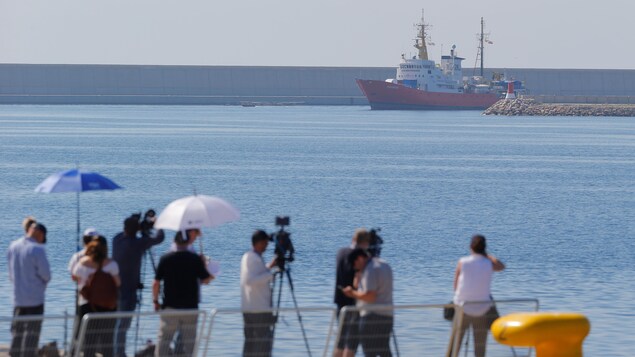 Des journalistes devant un bateau. Des journalistes devant un bateau.