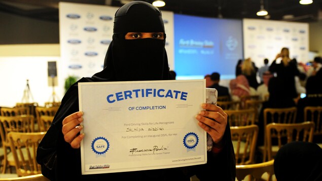 Une femme portant un niqab montre un certificat lui permettant de conduire en Arabie saoudite. Une femme portant un niqab montre un certificat lui permettant de conduire en Arabie saoudite.