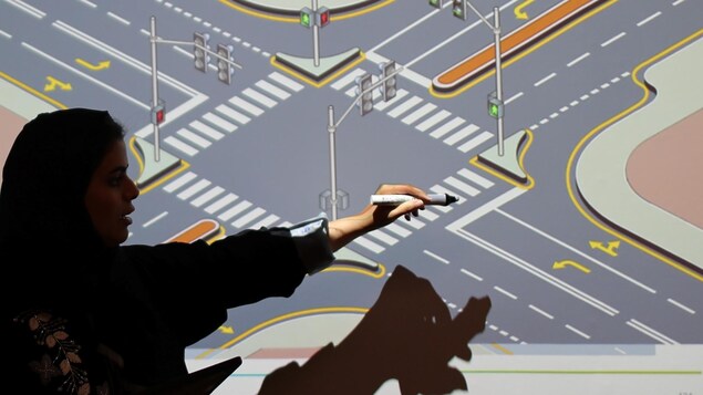 Une instructrice montre les règles de la route sur un écran. Une instructrice montre les règles de la route sur un écran.