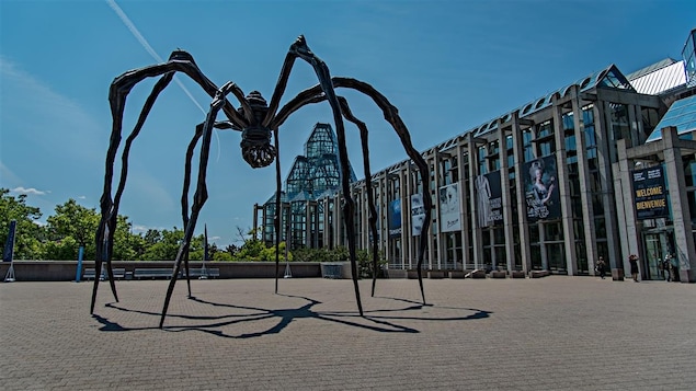 Une sculpture d'araignée en fer forgé devant un musée 