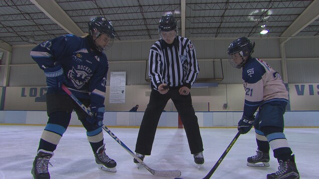 Un jeune arbitre procède à une mise au jeu.