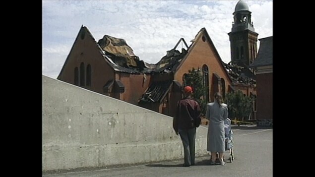 Deux personnes regardent les ruines d'une église. 