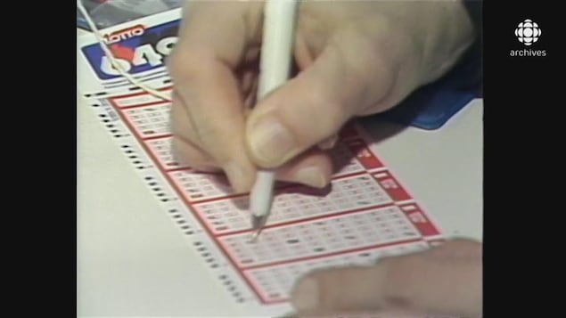 Main remplissant au stylo les numéros d'un billet de Lotto 6/49