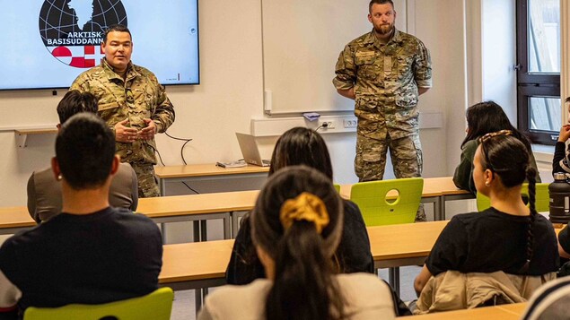 Two men in uniform address  a classroom. 