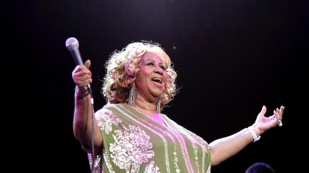 Aretha Franklin écarte les bras, alors qu'elle tient le micro dans sa main droite, et chante, lors d'un concert à New York, en 2012. Aretha Franklin écarte les bras, alors qu'elle tient le micro dans sa main droite, et chante, lors d'un concert à New York, en 2012.