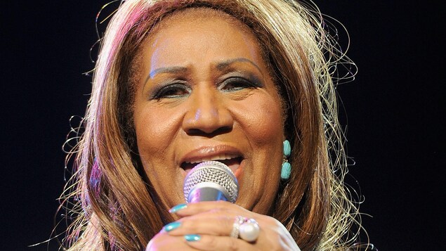 La chanteuse tient son micro avec ses deux mains. La chanteuse tient son micro avec ses deux mains.
