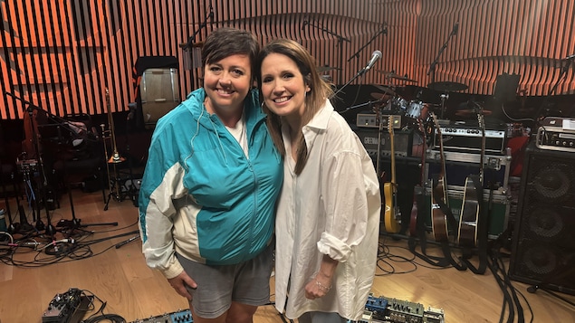 Les deux femmes sourient dans un studio rempli d'instruments.