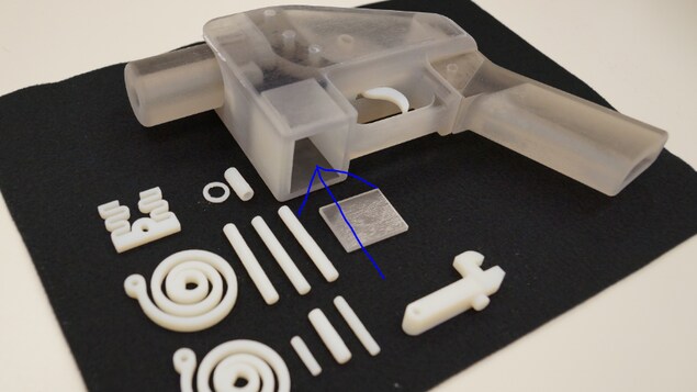 Une photo du manuel pour le pistolet imprimable 3D Liberator qui montre une flèche bleue pointant une cavité où les utilisateurs sont invités à insérer un morceau de métal pour s'assurer que l'arme est conforme aux lois américaines. Une photo du manuel pour le pistolet imprimable 3D Liberator qui montre une flèche bleue pointant une cavité où les utilisateurs sont invités à insérer un morceau de métal pour s'assurer que l'arme est conforme aux lois américaines.