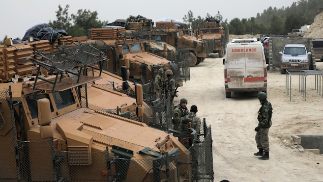 Des soldats turcs circulent parmi des camions de l'armée. Des soldats turcs circulent parmi des camions de l'armée.