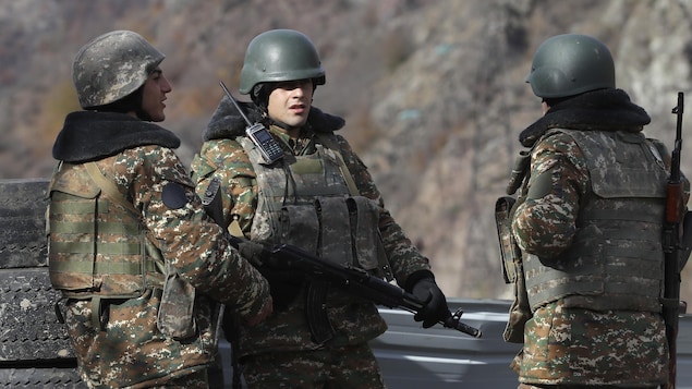 Des militants armés et habillés en tenues militaires.
