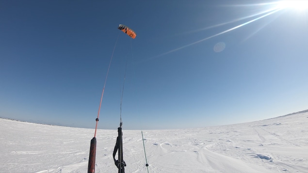 Une image prise au grand angle d'un cerf volant attaché au photographe par des sangles, et tendu vers l'immensité du ciel bleu de l'arctique. Une image prise au grand angle d'un cerf volant attaché au photographe par des sangles, et tendu vers l'immensité du ciel bleu de l'arctique.