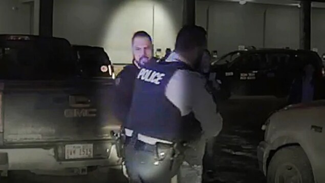 Un policier derrière un collègue lors d'une arrestation.