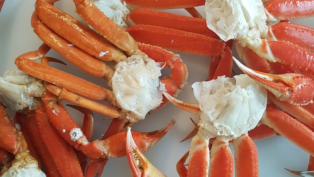 Des crabes des neiges cuits posés sur une planche à découper.