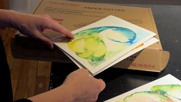 Une personne tient une oeuvre d'aquarelle